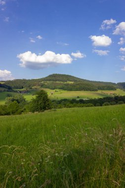Bahar yeşil alanları mavi gökyüzü ve bulutlar bir dağlık güney Almanya kırsal kırsal manzara
