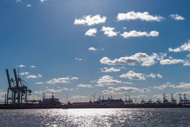 Hamburg konteyner terminal bağlantı noktası Dock teçhizatları ve gemilerde bir sprintime Mart öğleden sonra güneş mavi gökyüzü ve bulutlar ile parlak