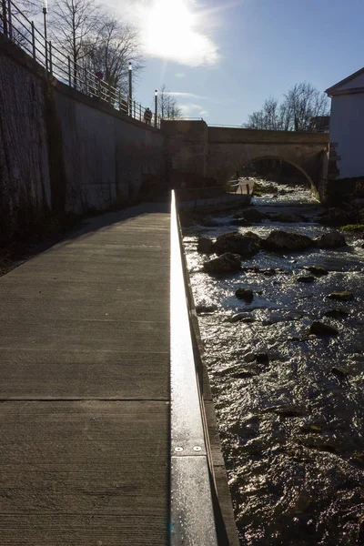 boulevard on a riverside with bridge and concrete elements in december christmas advent in south germany blue sunny day near city of munich and stuttgart