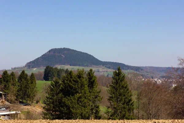 Central German Uplands on easter springtime holiday with blue sky and green fields forest trees