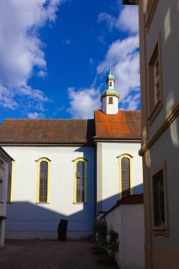 mavi gökyüzü güneş bahar gün Güney Alman kenti schwaebisch gmuend stuttgart yakınındaki mavi sarı cephe ile catholich Kilisesi
