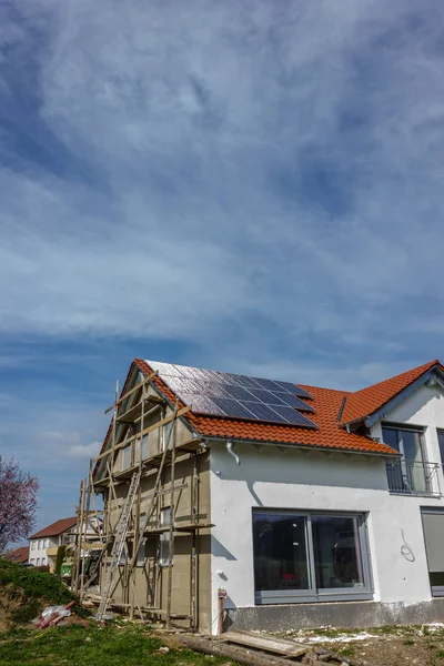 framing house with solar panels on rooftop at south german countryside april springtime afternoon