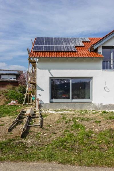 framing house with solar panels on rooftop at south german countryside april springtime afternoon