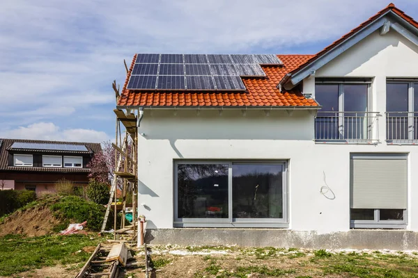 framing house with solar panels on rooftop at south german countryside april springtime afternoon