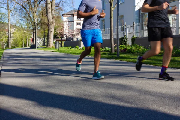 Two young men jogging in park — Zdjęcie stockowe