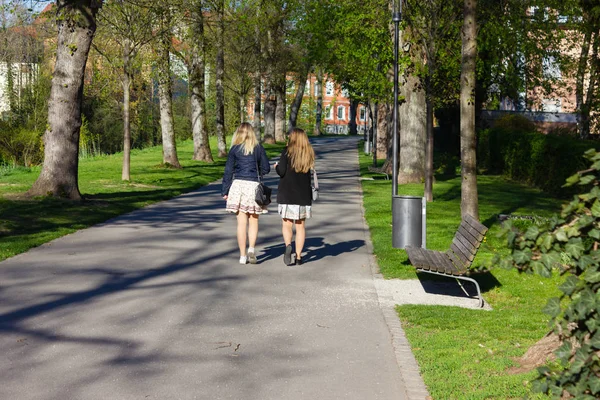 Dos mujeres jóvenes caminando en el parque después de ir de compras — Foto de Stock