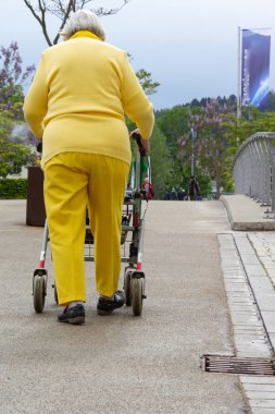 rollator ile sarı elbiseli kıdemli bayan
