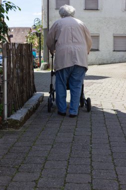 Rollator ile yürüyen kıdemli insanlar