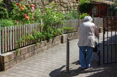 Rollator ile yürüyen kıdemli insanlar