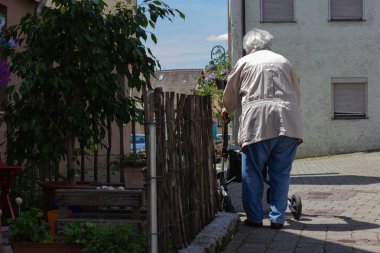 Rollator ile yürüyen kıdemli insanlar