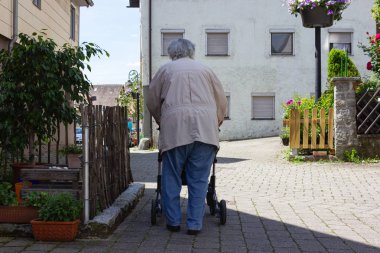Rollator ile yürüyen kıdemli insanlar