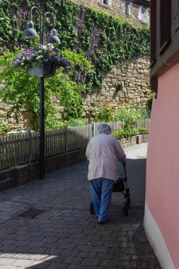 Rollator ile yürüyen kıdemli insanlar