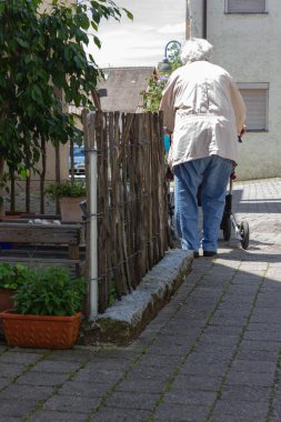 Rollator ile yürüyen kıdemli insanlar