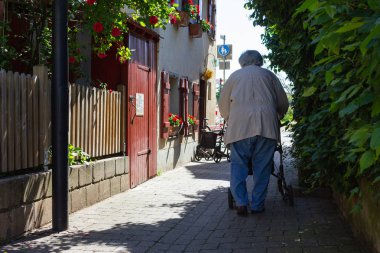 Rollator ile yürüyen kıdemli insanlar