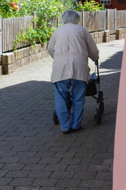 Rollator ile yürüyen kıdemli insanlar