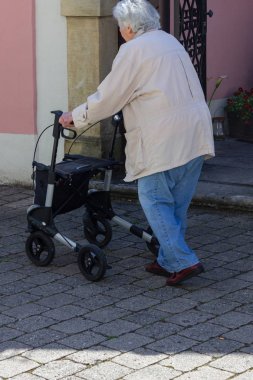 Rollator ile yürüyen kıdemli insanlar