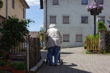 Rollator ile yürüyen kıdemli insanlar