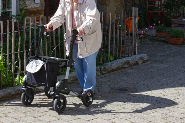 Пожилые люди, идущие с роликом — стоковое фото