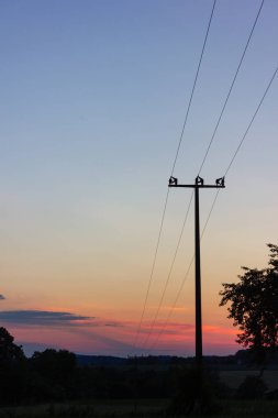 renkli günbatımında telgraf direği