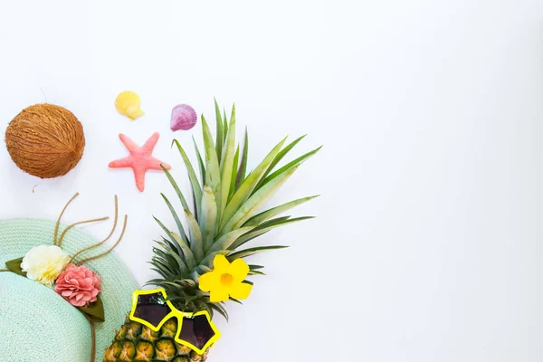 Hipster ananas moda tropikal meyve, deniz kabukları ve deniz yıldızı. Yaz tatil arka plan kavramı. Üstten görünüm, düz yatıyordu