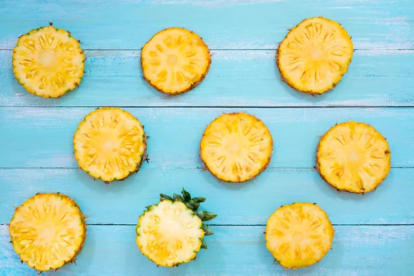 Tropikal ananas dilimleri ahşap üzerine mavi renk plank. yaz meyve backgrond kavramı, üstten görünüm, desen
