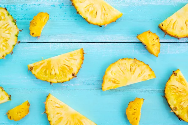 Tropikal ananas dilimleri ahşap üzerine mavi renk plank. çerçeve düzeni yaz tatil arka plan kavramı. üstten görünüm, desen