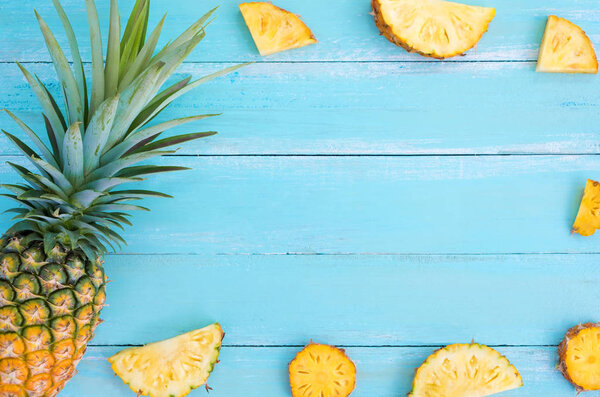 Tropical pineapple on wood plank blue color. frame layout summer vacation background concept.