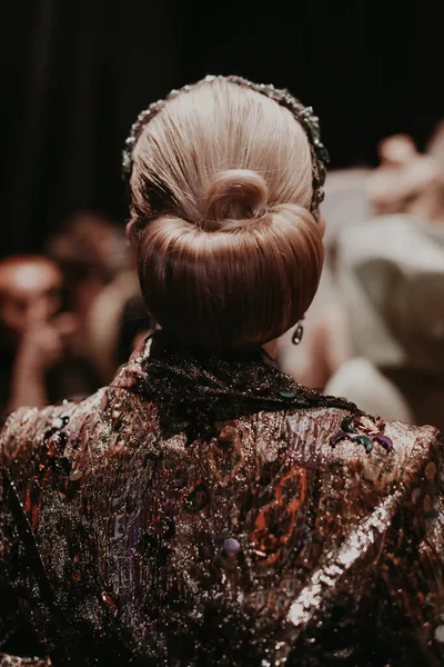 Close up back of the model in the patterned designer high fashion jacket with beautiful hairstyle on backstage of fashion week