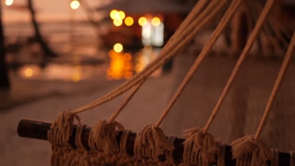 Cozy white hammock on the beach against a background of the swimming pool, ocean and sunset. — Stock Video