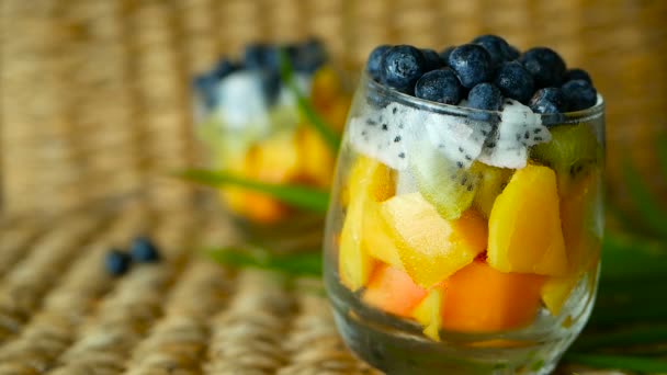 Salade de mélange tropical coloré dans un bocal. Frais divers types de baies et de fruits biologiques crus dans un bol en verre. Végétarien sain — Video