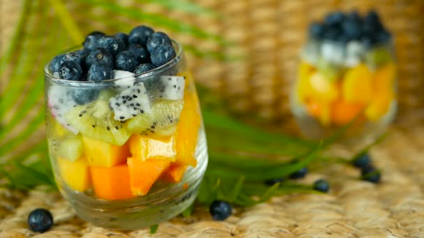 Ensalada de mezcla tropical colorida en frasco. Fresco varios tipos de bayas orgánicas crudas y frutas en tazón de cristal. Vegetariano saludable — Vídeo de stock