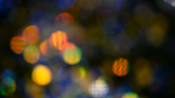 Oskärpa skimrande mångfärgade glitter konfetti, svart bakgrund. Holiday abstrakt festliga bokeh ljusa fläckar. — Stockvideo