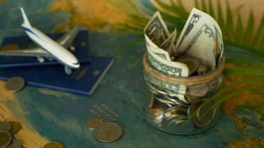 Seyahat bütçe kavramı. Tasarruf tatil için cam kavanozun içinde dünya harita arka plan üzerinde