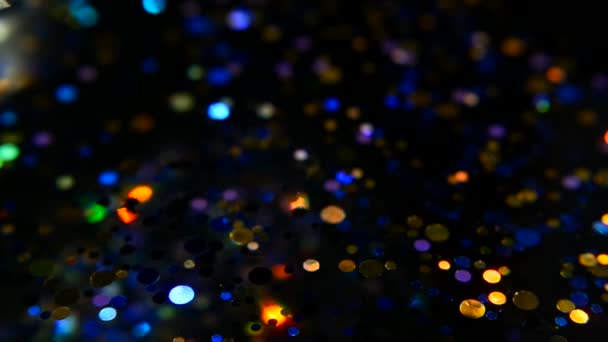 Desenfocado brillante confeti brillo multicolor, fondo negro. Vacaciones abstracto festivo bokeh puntos de luz . — Vídeos de Stock