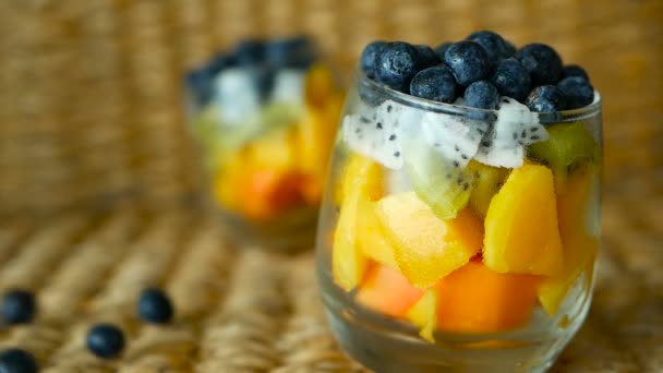 Salade de mélange tropical coloré dans un bocal. Frais divers types de baies et de fruits biologiques crus dans un bol en verre. Végétarien sain — Video