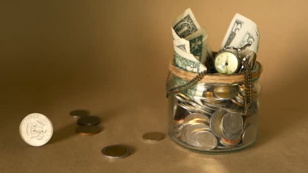 在罐子里省钱。投资的象征, 保持金钱的概念。在玻璃锡 moneybox 收集现金钞票 — 图库视频影像