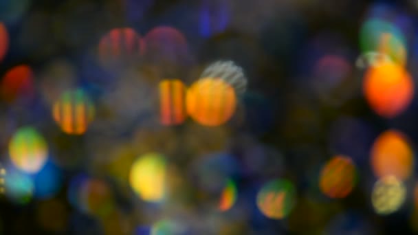 Defokussiert schimmerndes buntes Glitzerkonfetti, schwarzer Hintergrund. Urlaub abstrakte festliche Bokeh Lichtpunkte. — Stockvideo