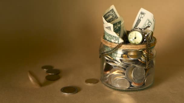 Saving money coin in jar. Symbol of investing, keeping money concept. Collecting cash banknotes in glass tin as moneybox — Stock Video