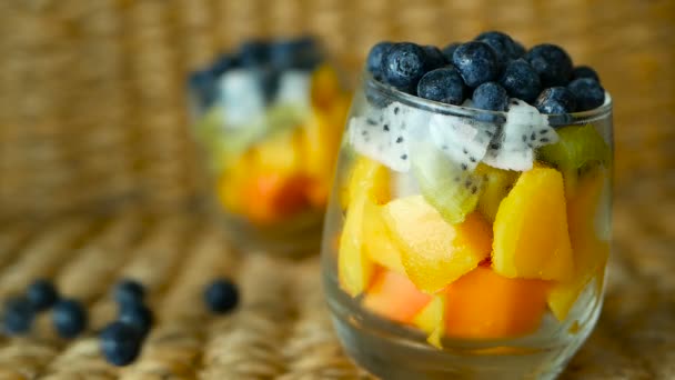 Salade de mélange tropical coloré dans un bocal. Frais divers types de baies et de fruits biologiques crus dans un bol en verre. Végétarien sain — Video