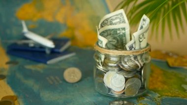 Seyahat bütçe kavramı. Tasarruf tatil için cam kavanozun içinde dünya harita arka plan üzerinde