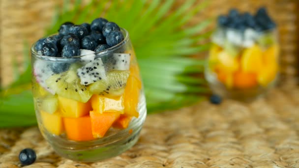 Salade de mélange tropical coloré dans un bocal. Frais divers types de baies et de fruits biologiques crus dans un bol en verre. Végétarien sain — Video