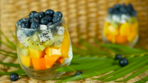 Salade de mélange tropical coloré dans un bocal. Frais divers types de baies et de fruits biologiques crus dans un bol en verre. Végétarien sain — Video