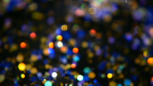 Rozostření, třpytivé konfety barevné třpytky, černém pozadí. Holiday abstraktní slavnostní bokeh lehké skvrny. — Stock video