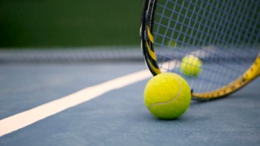 Sahada tenis donatımın kapatın. Spor, eğlence kavramı. Hareket kopya alanı ve yumuşak odak ile beyaz çizgi yanında bir kil yeşil mavi kortta tenis topuyla sarı raket.