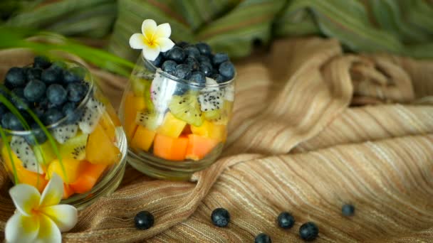 Salade de mélange tropical coloré dans un bocal. Frais divers types de baies et de fruits biologiques crus dans un bol en verre. Végétarien sain — Video