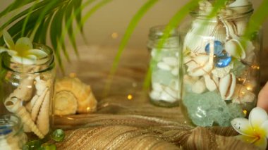 Deniz kabuklarını, mercanlar, deniz öğeleri bokeh ışıkları ile plumeria frangipani çiçek dekorasyonu için ile dolu cam kavanoz