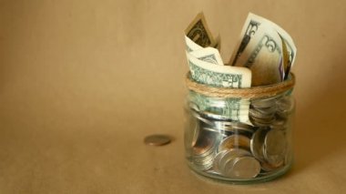 Para sikke kavanoza kaydetme. Yatırım, para kavramı koruma sembol. Nakit banknot cam teneke içinde servet toplama