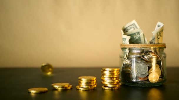 Saving money coin in jar. Symbol of investing, keeping money concept. Collecting cash banknotes in glass tin as moneybox — Stock Video