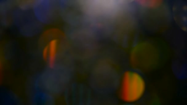 Confettis scintillants multicolores déconcentrés, fond noir. vacances abstraites festives bokeh spots lumineux . — Video