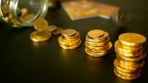 Symbol für Investieren, Geld behalten Konzept. Nahaufnahme Stillleben mit zunehmenden Säulen von Goldmünzen auf schwarzem Tisch — Stockvideo